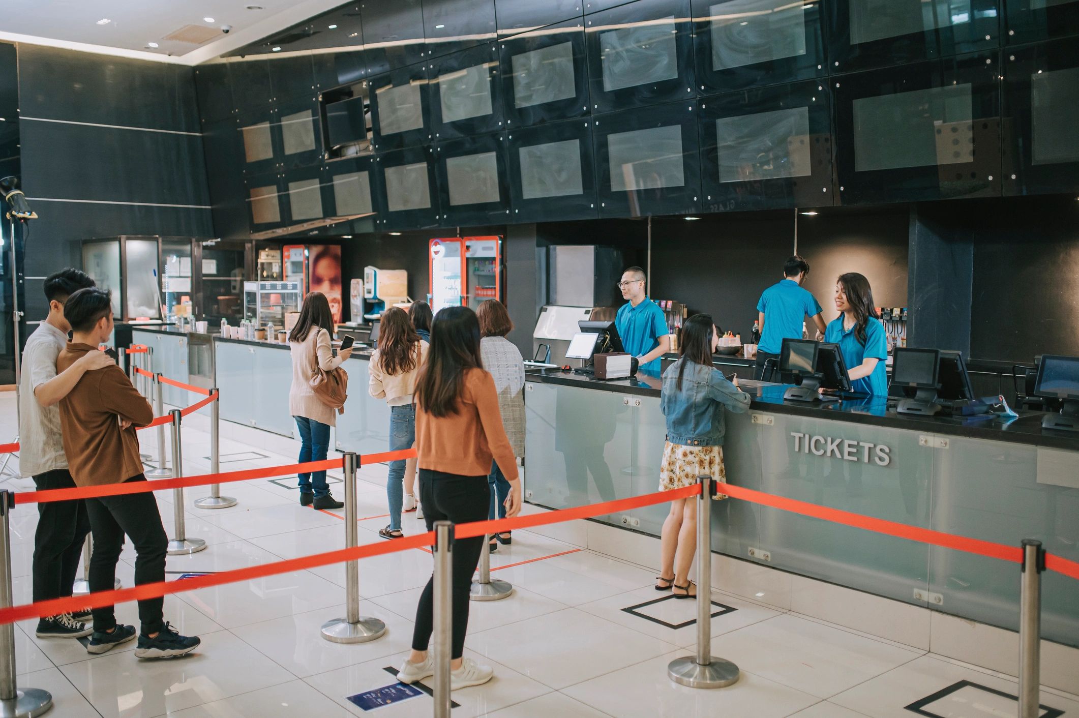 Moviegoers at a cinema ticket counter before a screening